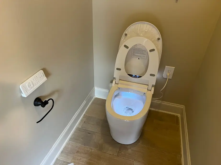 Installed smart toilet with a bidet seat and wall remote