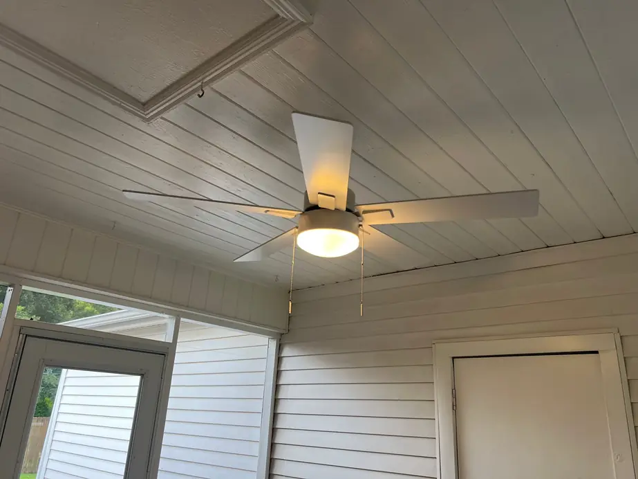 Ceiling fan with a light kit on a white beadboard porch ceiling