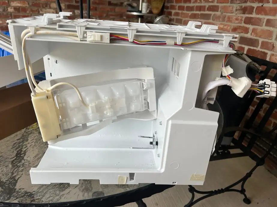 Refrigerator ice-maker assembly removed and set on a patio table